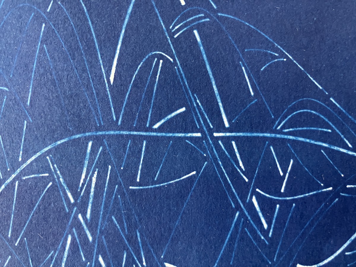 Closeup of white lines against a blue background. A lot of blue is bleeding into the lines.